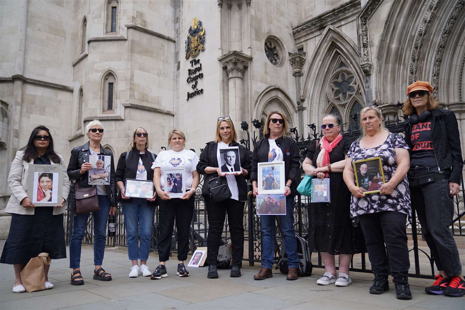 Campaigners held up pictures of their relatives that died during the pandemic ahead of the hearing at the Royal Courts of Justice in London (Lucy North/PA)