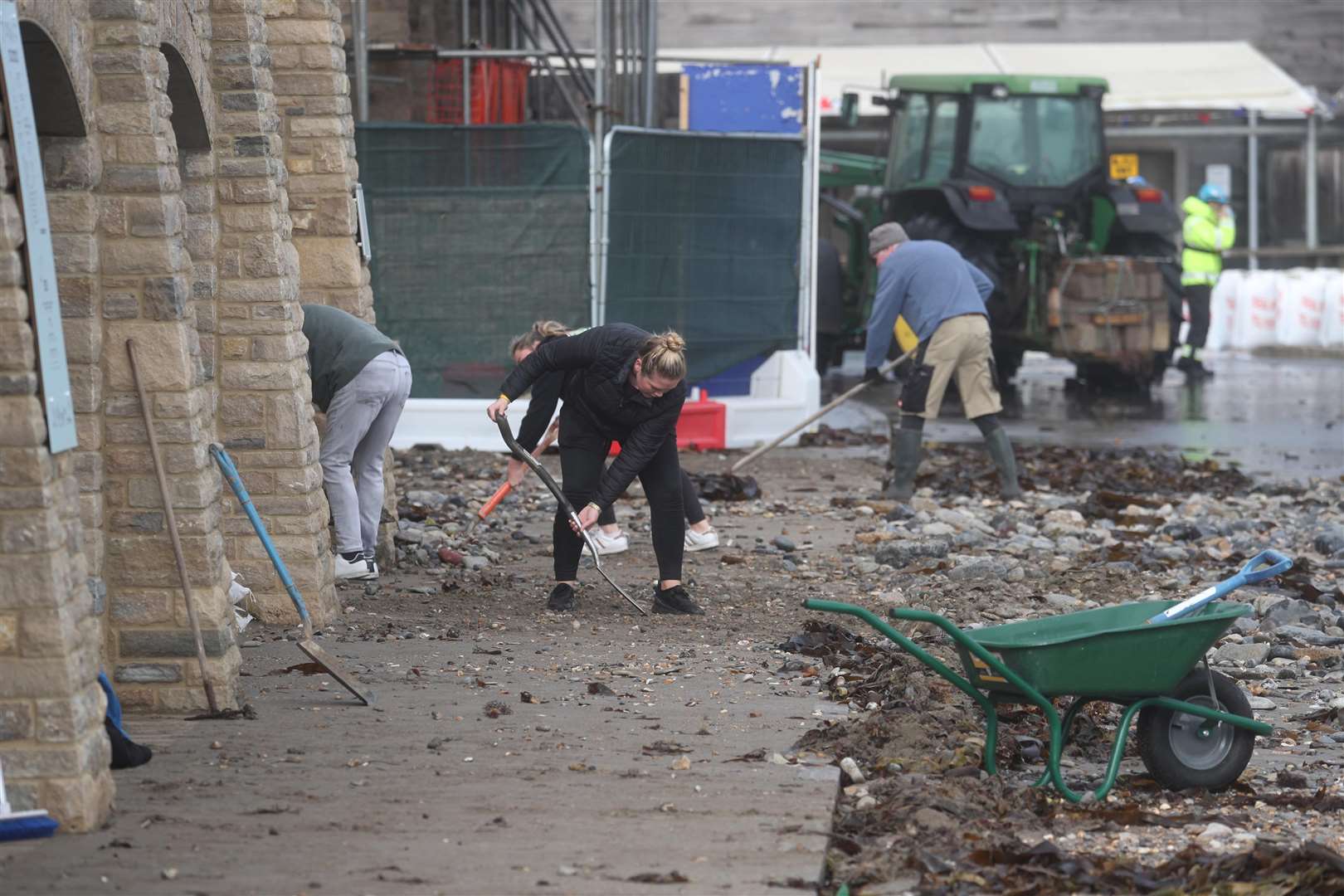 People clean up stones brought in by the sea in Swanage (Steve Parsons/PA)