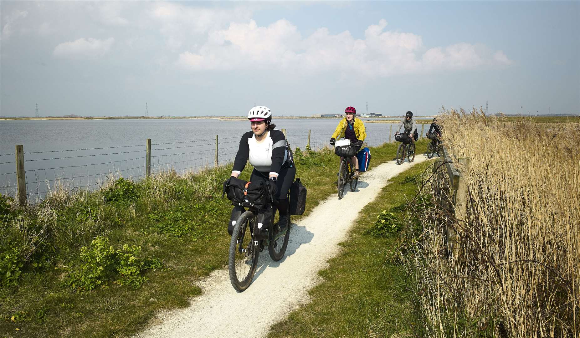 Cyclists ride past a lake near Lydd, Kent, on Cycling UK’s Cantii Way route (Cycling UK)