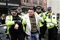 Tommy Robinson escorted from march against antisemitism as thousands gather