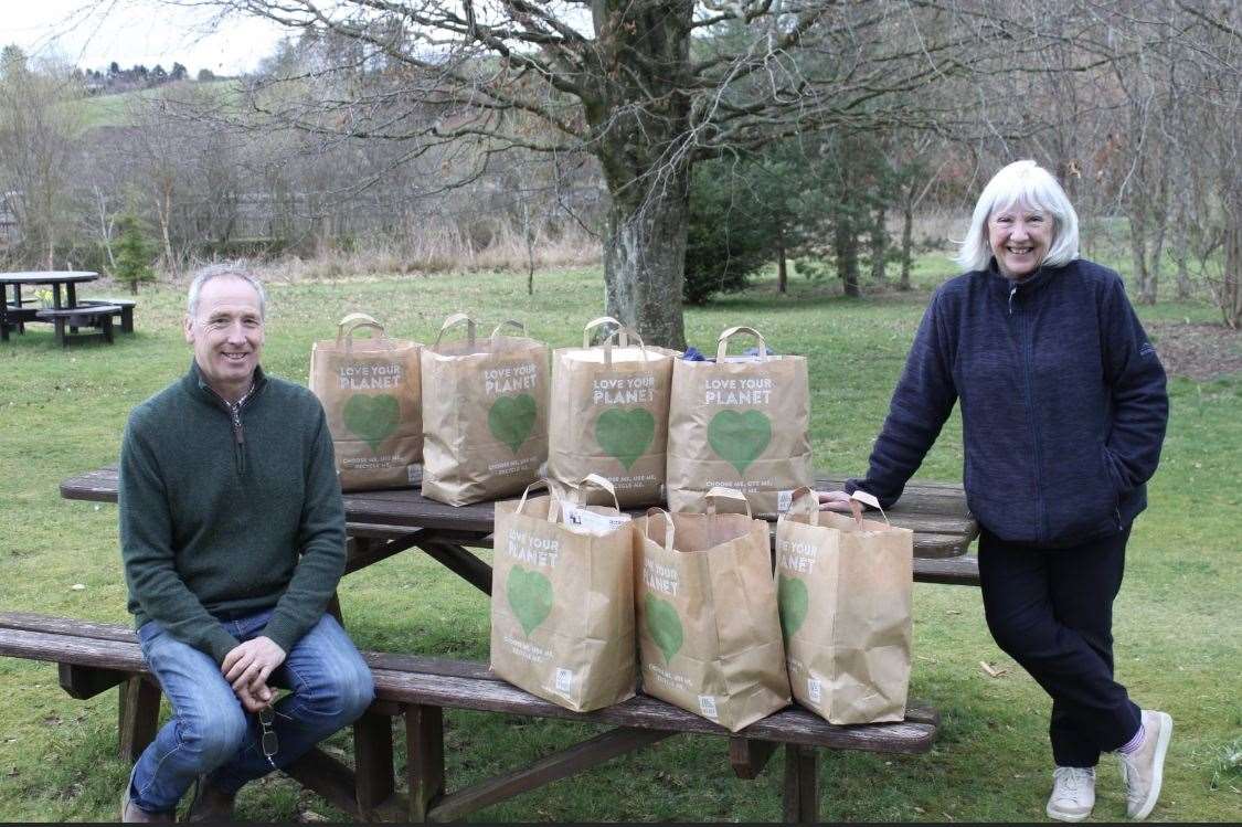 President of Ythan Valley Eleanor Macalister handing over 7 packs of clothes to president of Central Buchan Keith Hendry.