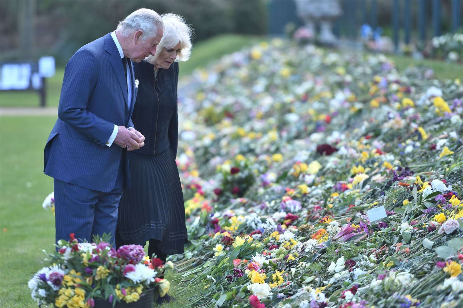 The Prince of Wales and the Duchess of Cornwall visit the gardens of Marlborough House to view the flowers and messages left by members of the public (Jeremy Selwyn/Evening Standard/PA)