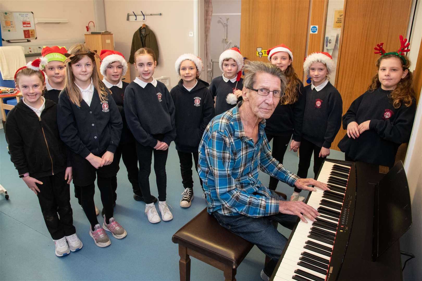 Patient Ziggy plays the piano as the Portessie kids sing some festive tunes. Picture: Daniel Forsyth