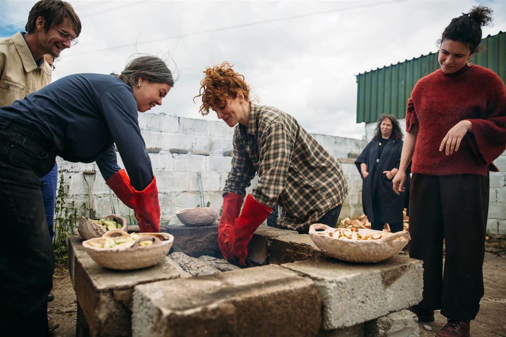 Artist Fionn Duffy and Misa Brzezicki of Deveron Projects lower clay covered brown trout into the outdoor oven...Picture: Jassy Earl