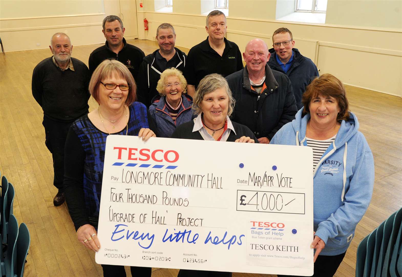 Tesco Service Manager Pat Allsop (centre) hands over a cheque for £4,000 to Longmore Hall Committee's chairwoman Rhona Paterson (right) and treasurer Linda Morrison. Other committee members stand behind. Picture: Eric Cormack. Image No. 044175.