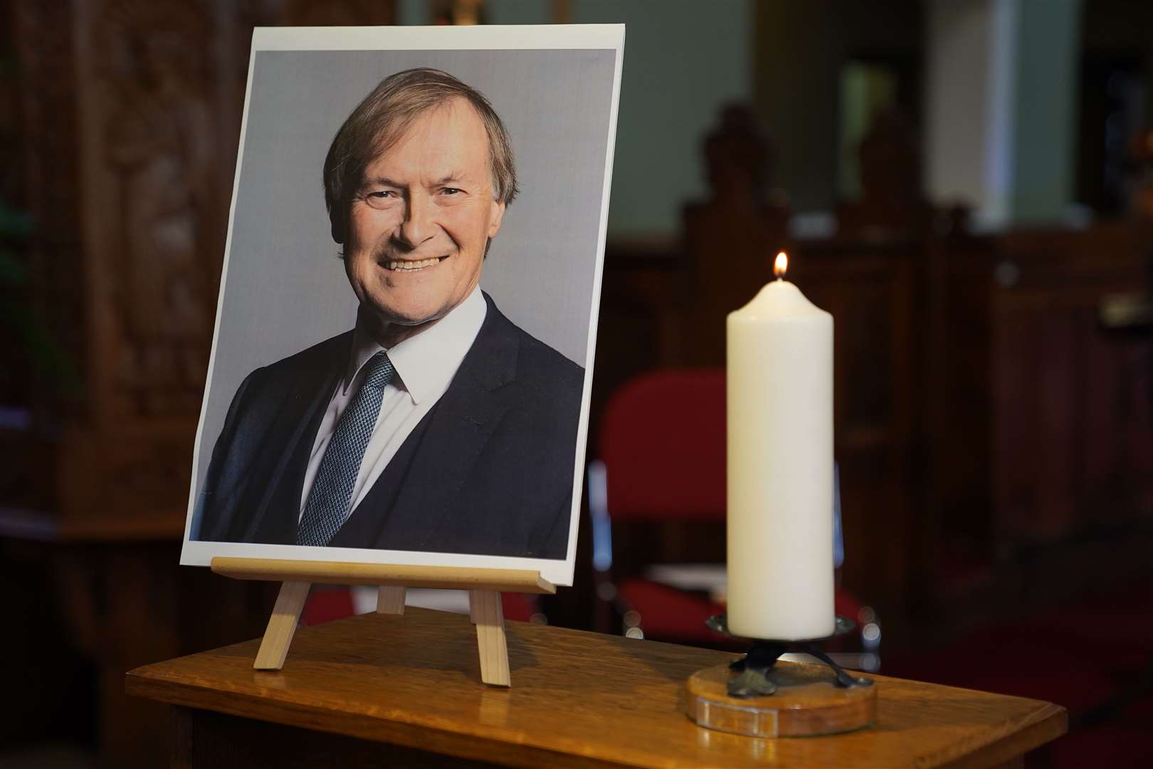 A candle and a photo at a vigil for Conservative MP Sir David Amess (Kirsty O’Connor/PA)