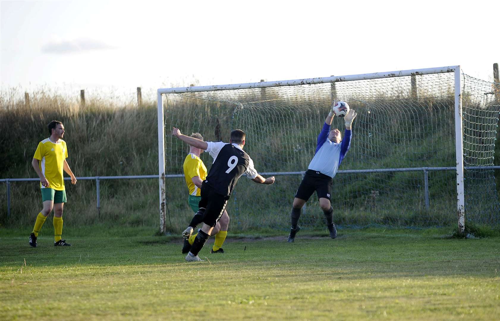 Hopeman keeper Glen Fraser pulls off a fine save from Russell McLaughlin's strike. Picture: Becky Saunderson..