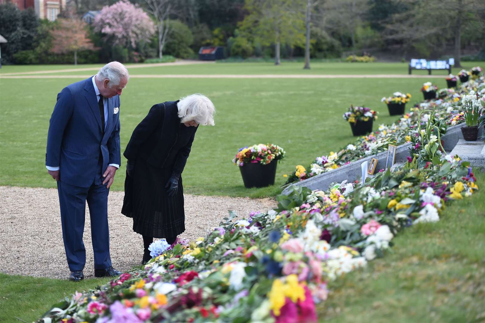 The Prince of Wales and the Duchess of Cornwall visit the gardens of Marlborough House, London, to view the flowers and messages left by members of the public outside Buckingham Palace (Jeremy Selwyn/Evening Standard/PA)
