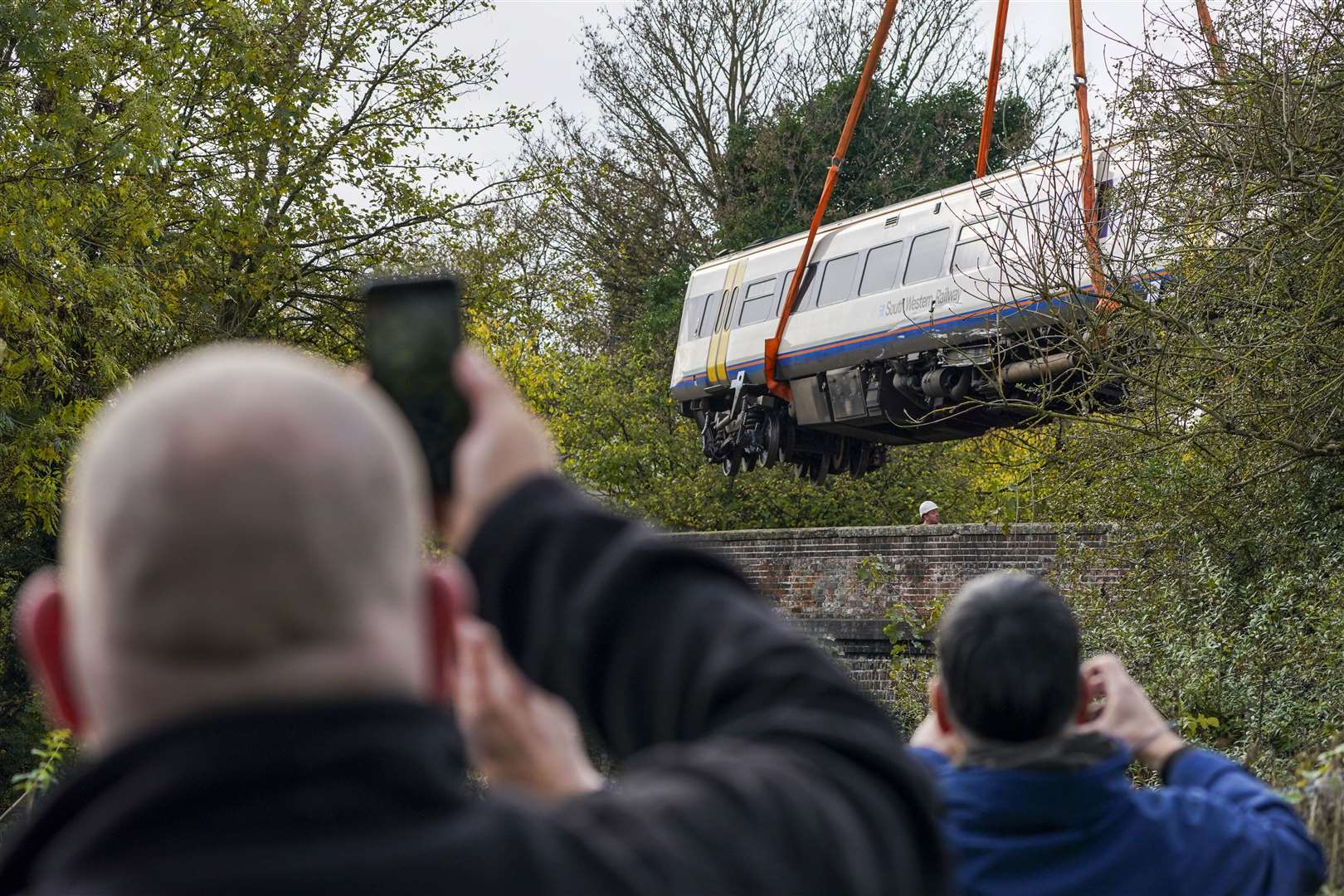A major operation was needed to reopen the line, including removing the train carriages (Steve Parsons/PA)