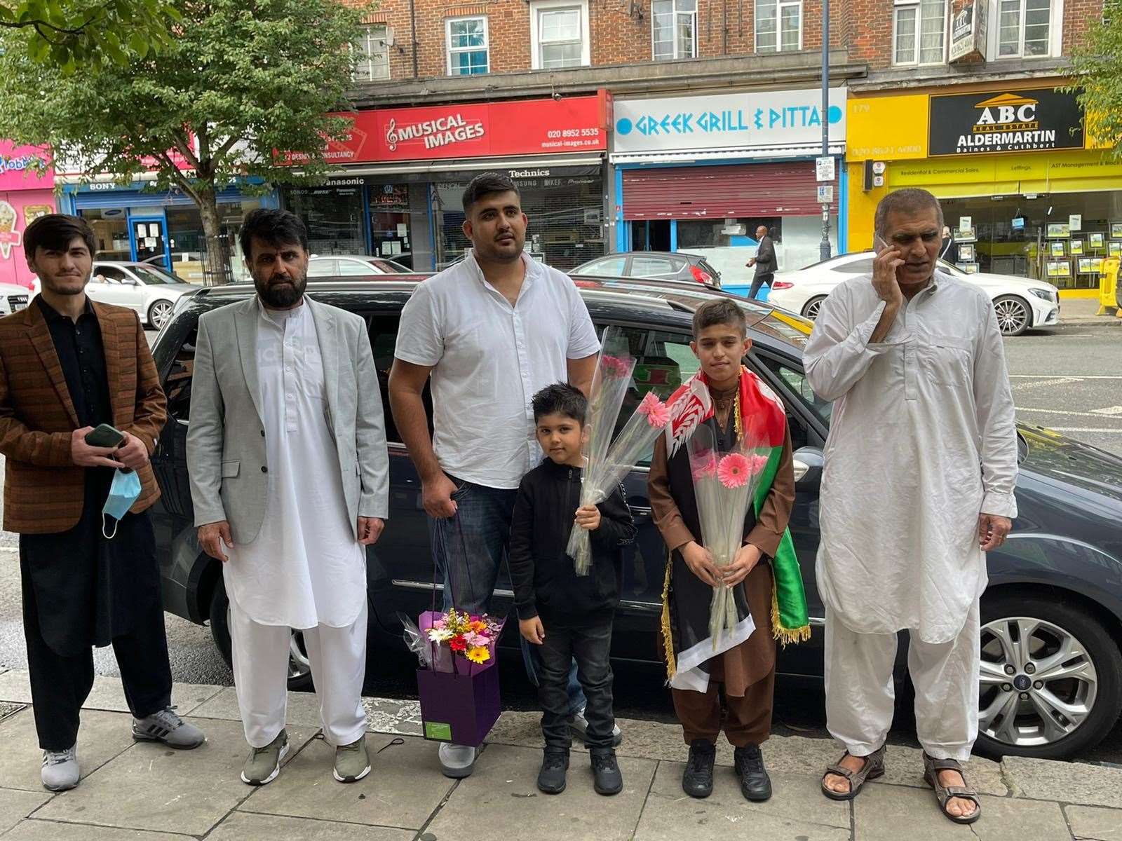 Obaidullah’s family including cousin Qamar (second left) and twin Irfanullah (second right) greeted him with gifts as he stepped off the train at St Pancras (PA)