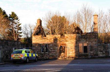 A police car outside the gutted shell of the building in Newmill.