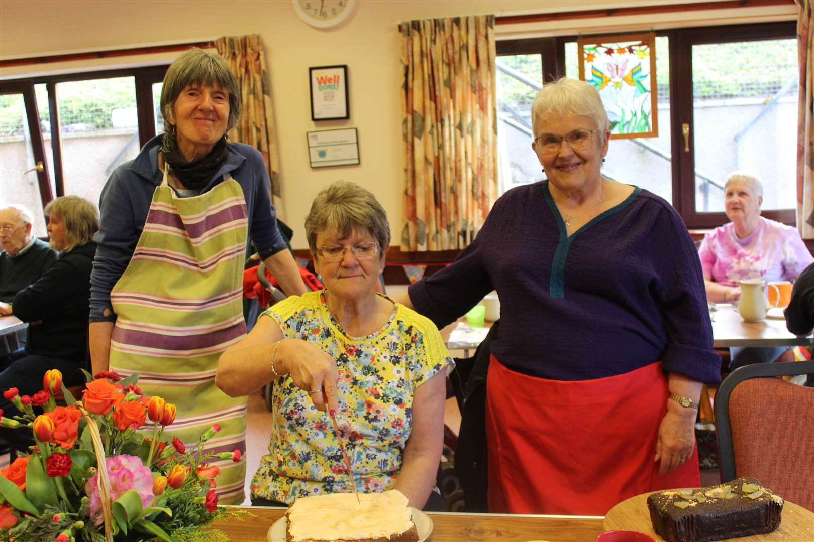 12th birthday party celebrations in Kemnay village hall for the weekly community coffee morning and Bargain Box with Liz Mackay (left) Gladys Wardle and Vera Walker with the carrot cake minus its candles last Friday morning. Picture:Griselda McGregor