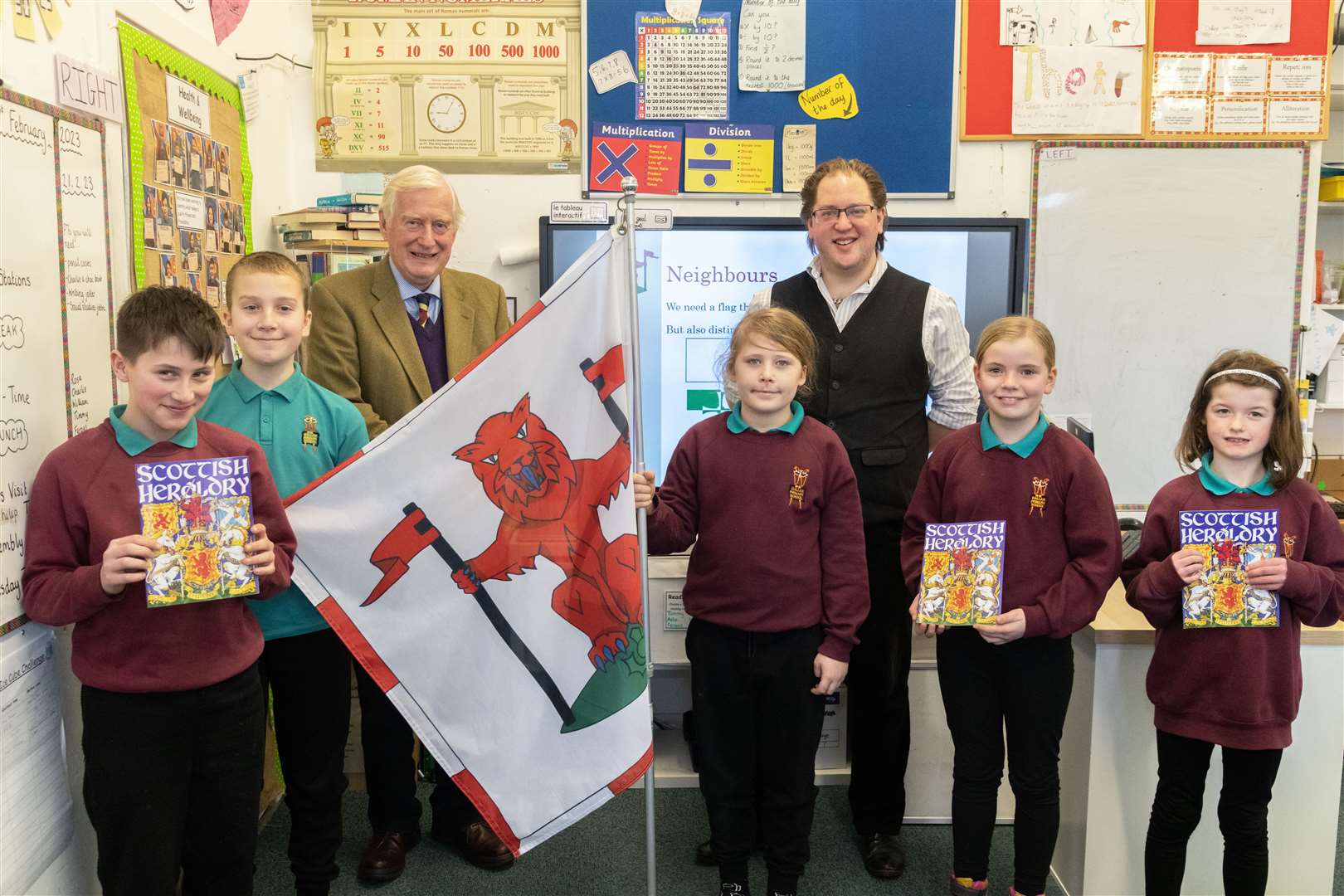 Vexillologist, Philip Tibbets (centre, right) and The Lord-Lieutenant of Moray, Major General Seymour Monro (centre, left) along with some pupils from Dallas Primary School which talks about the upcoming competition. ..Picture: Beth Taylor.