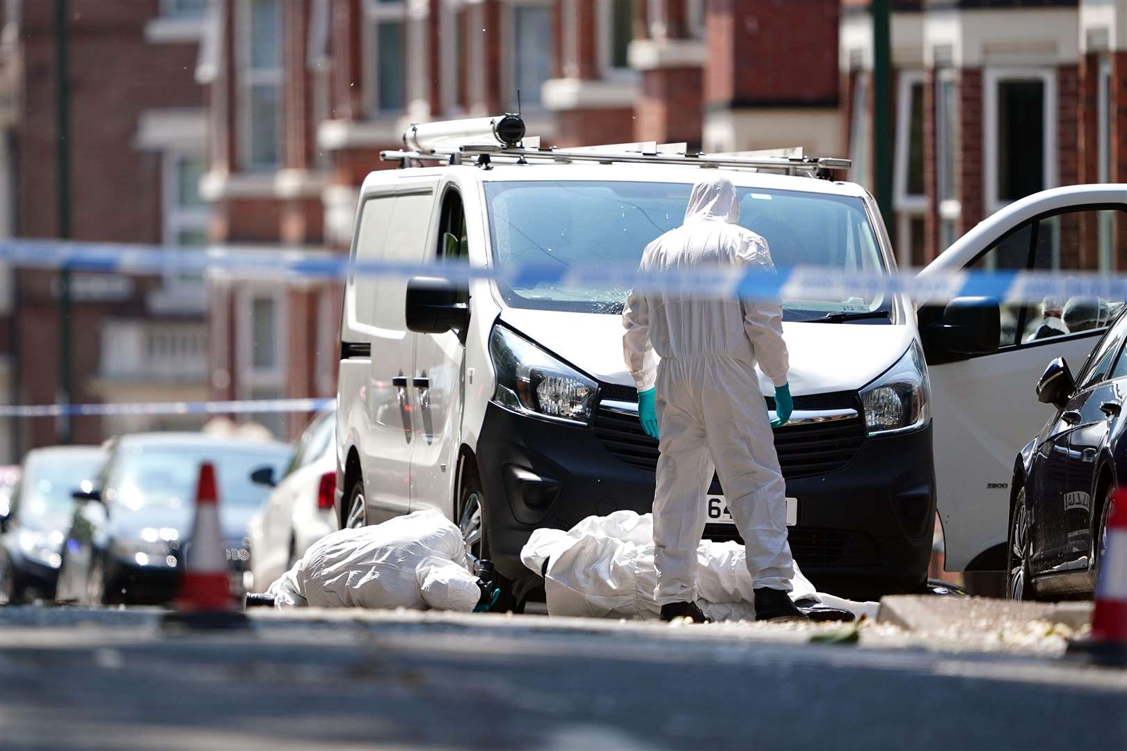 Police forensics officers search a white van on the corner of Maples Street and Bentinck Road in Nottingham (Zac Goodwin/PA)