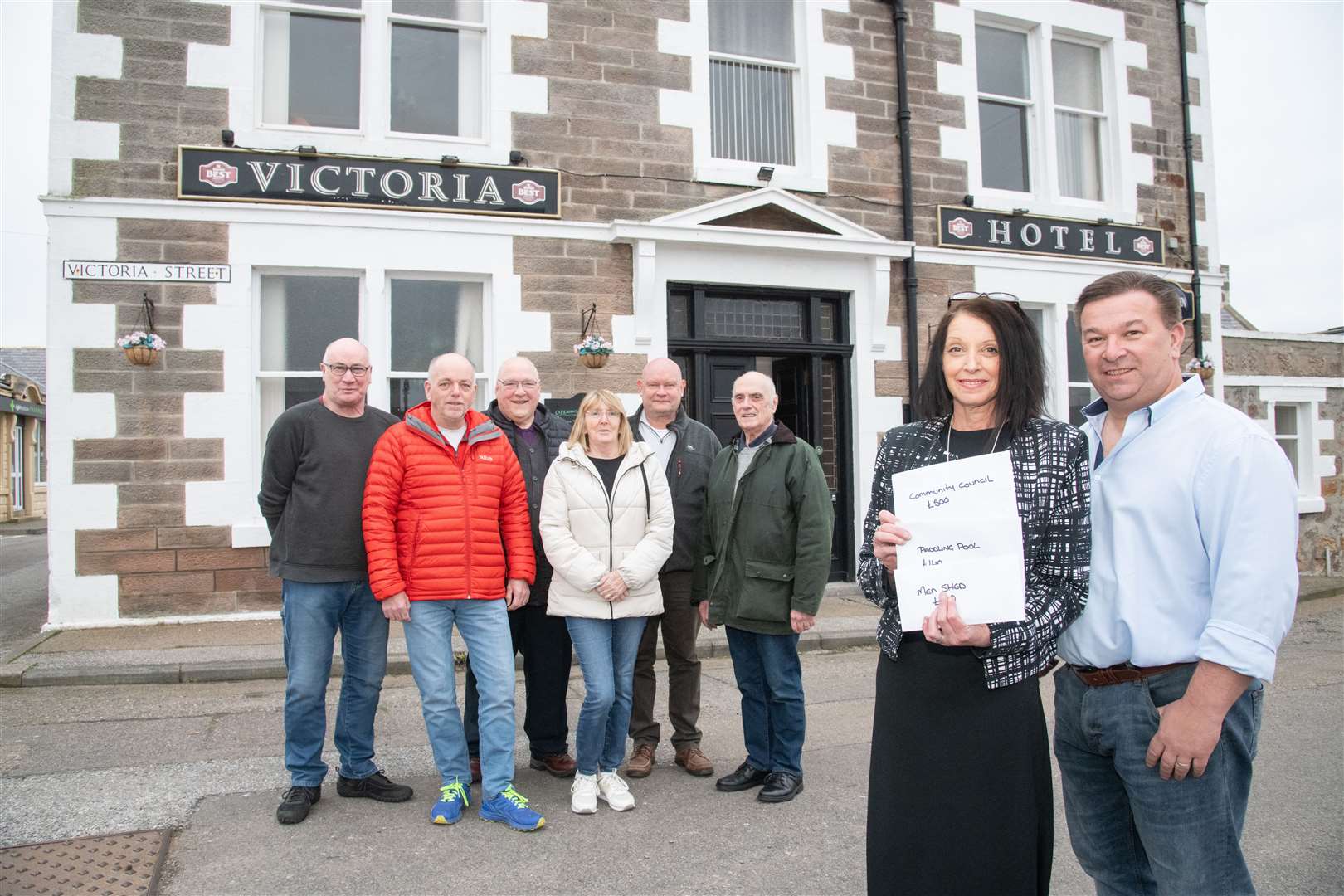 Victoria Hotel owners Lorraine and David Boa hand over donations to (back, from left) John Begg, Allan Gargan, Jimmy Bremner (all Finechty Men's Shed), Lil Urquhart (Portknockie Paddling Pool Committee), Andy Richards (Finechty Men's Shed) and PCA chairman John Going. Picture: Daniel Forsyth