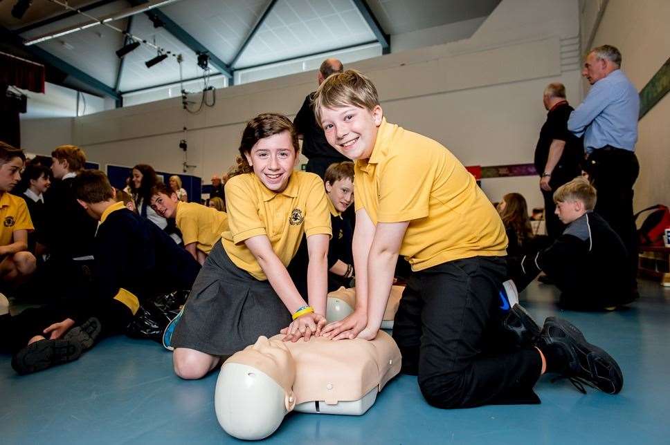 School children learning CPR.