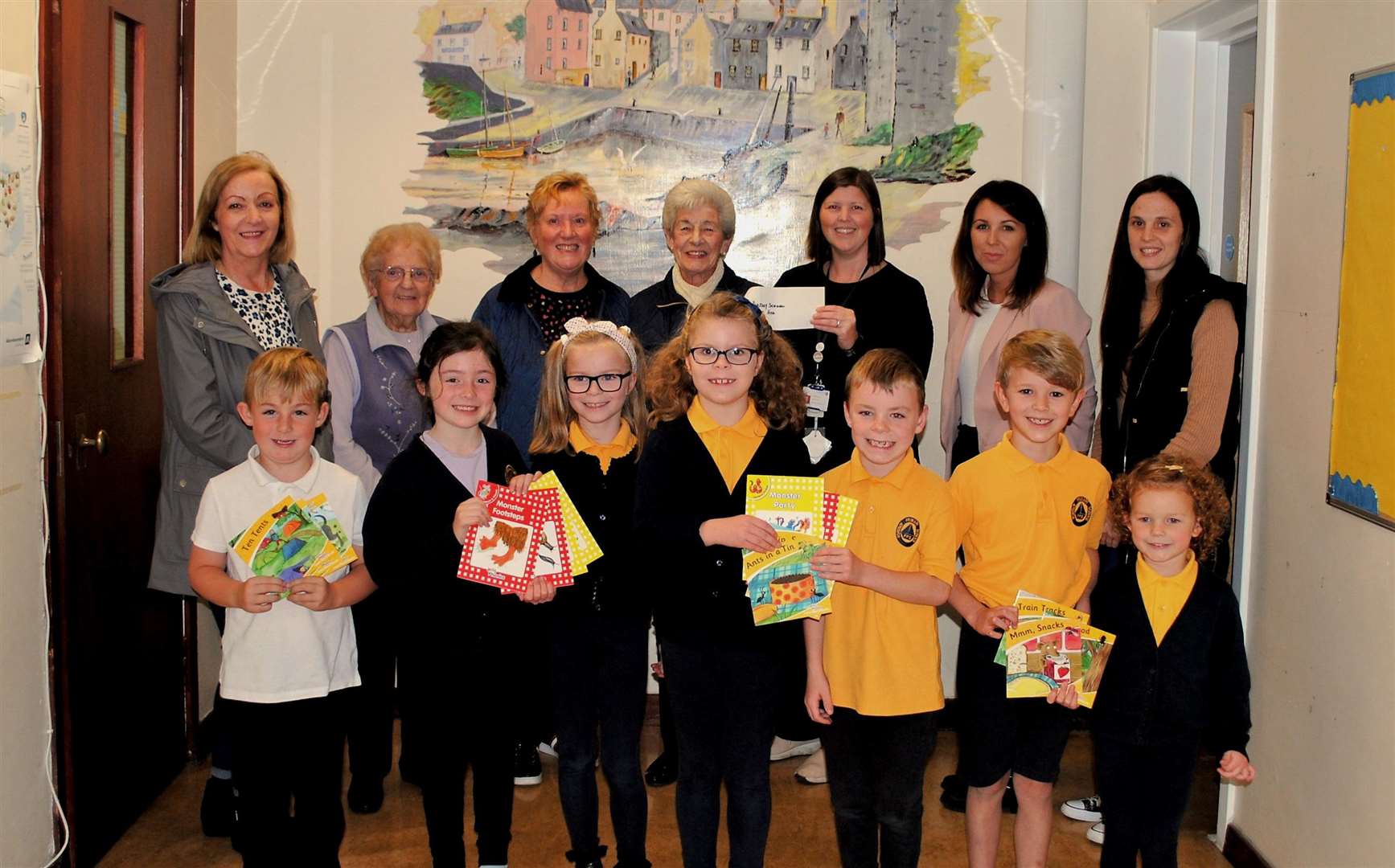 Portsoy Thrift Shop volunteers hand over the donation to head teacher Linda O'Donnell, Parents Support Group Representatvies and pupils.