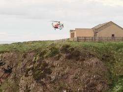 Coastguard helicopter Rescue 951 hovers above the site of the accident at Portknockie.