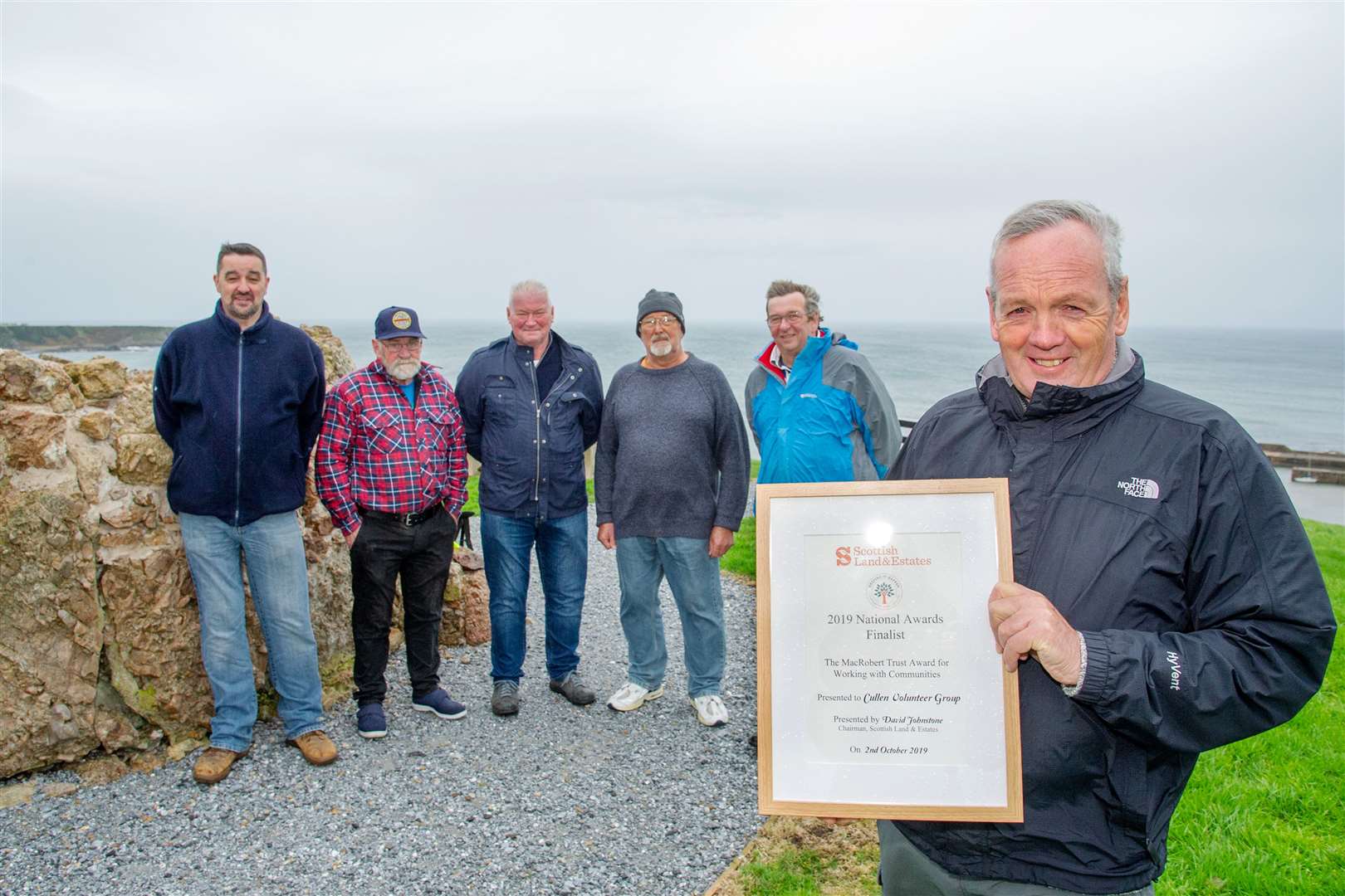 CVG treasurer Barry Addison proudly shows off the group's award final shortlist certificate, joined by other team members. Picture: Daniel Forsyth.