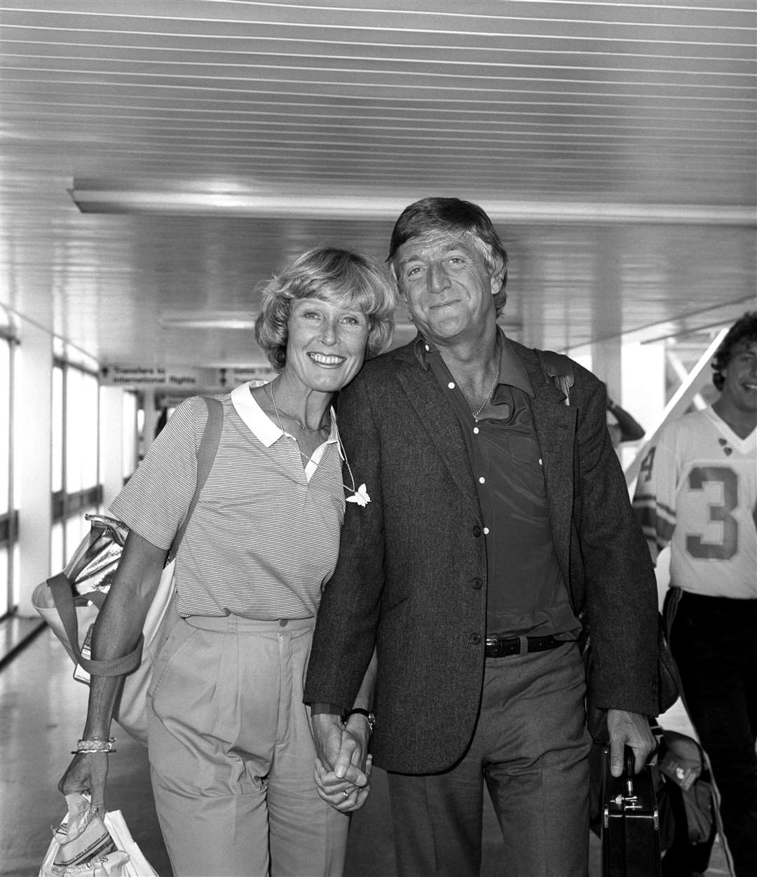 Sir Michael with his wife Mary at Heathrow Airport (PA)