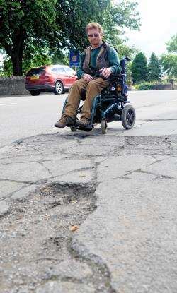 Don Ferguson caught his wheel on the broken pavement and fell partly on the main A96.