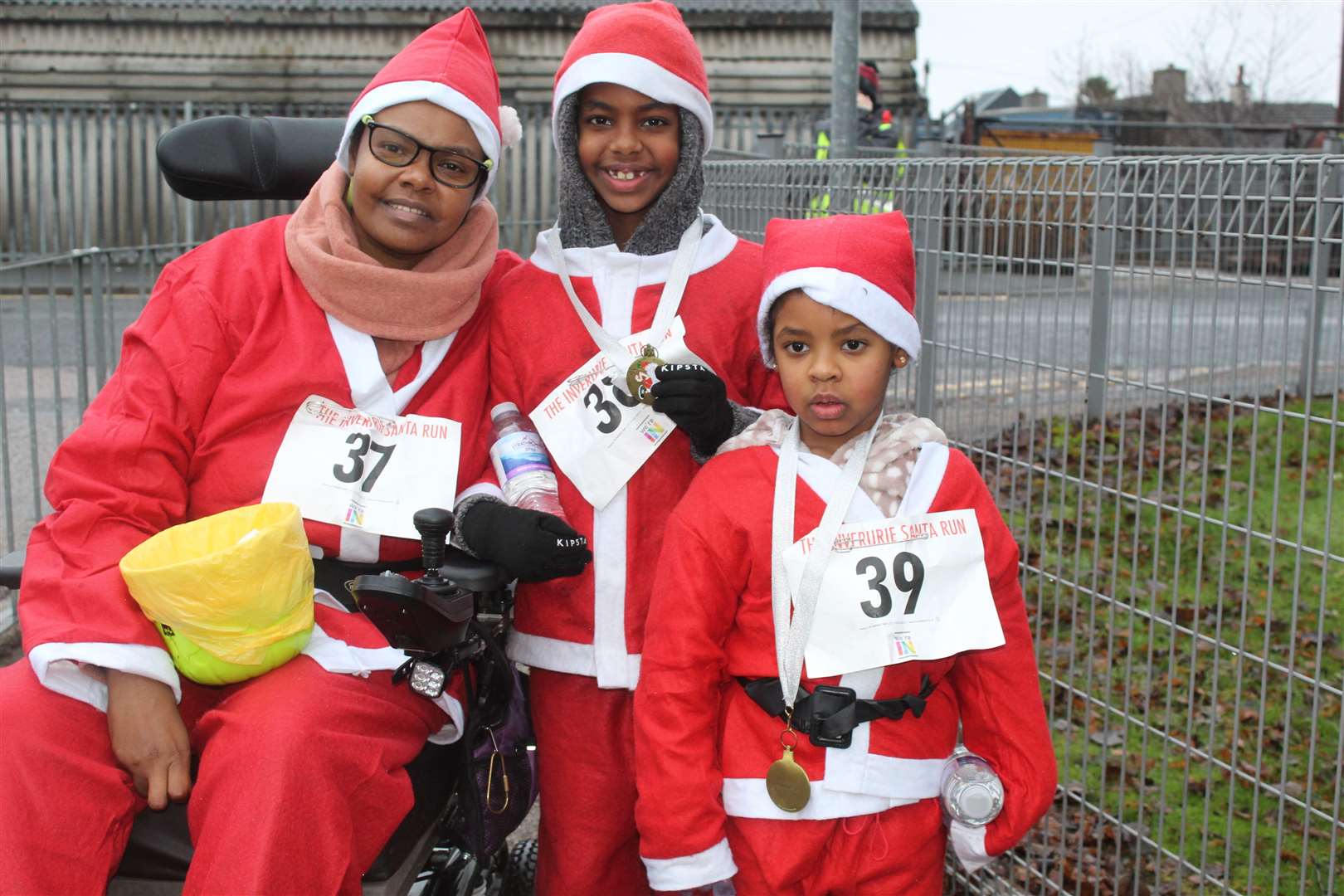 Sole wheelchair Santa run participant May Eltayeb was cheered on by her son and daughter Ahmed and Isla at Sunday's Santa run from Strathburn primary school. Picture: Griselda McGregor