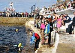 Safe haven...Participants at last year's bay swim are greeted and helped from the water at Macduff Harbour