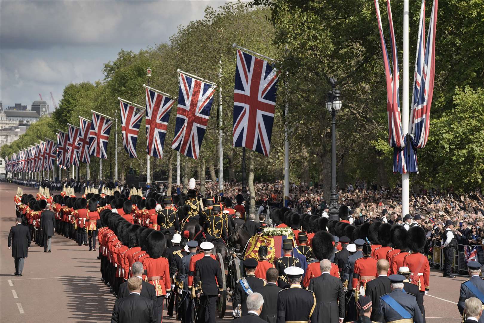 The coffin of the Queen, draped in the Royal Standard, is carried on a horse-drawn gun carriage during the ceremonial procession from Buckingham Palace to Westminster Hall (Vadim Ghirda/PA)