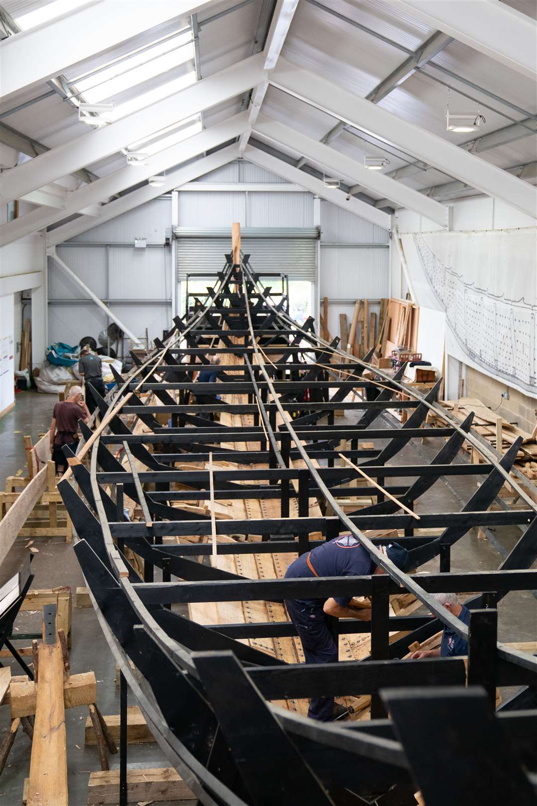 Volunteers work on the replica of the Sutton Hoo longship, at the Longshed in Woodbridge, Suffolk (Joe Giddens/PA)