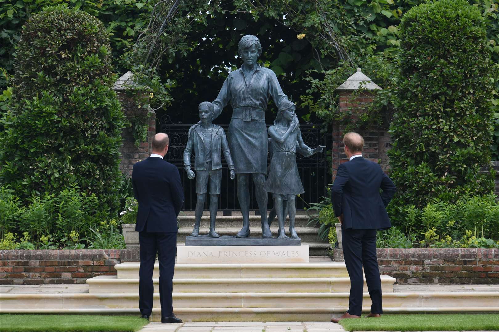 The then Duke of Cambridge (left) and Duke of Sussex look at a statue they commissioned of their mother Diana, Princess of Wales, in the Sunken Garden at Kensington Palace (Dominic Lipinski/PA)