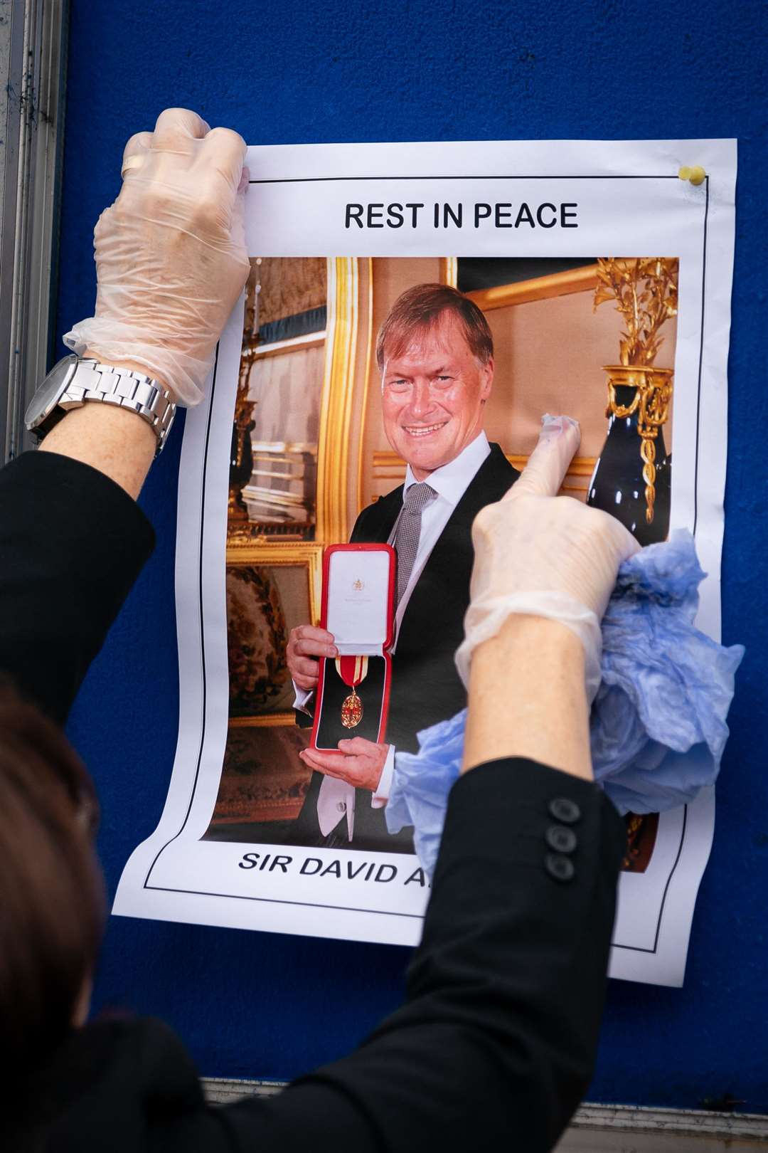 A photograph of Sir David Amess is placed on a noticeboard outside Iveagh Hall, the home of the Southend West Conservative Association in Leigh-on-Sea, Essex (Aaron Chown/PA)