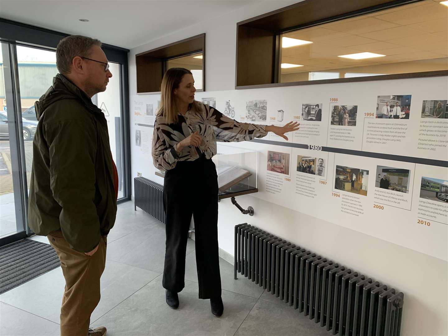 Kelly Abel, HR director of Laings of Inverurie shows MP Richard Thomson the historic timeline of the company.