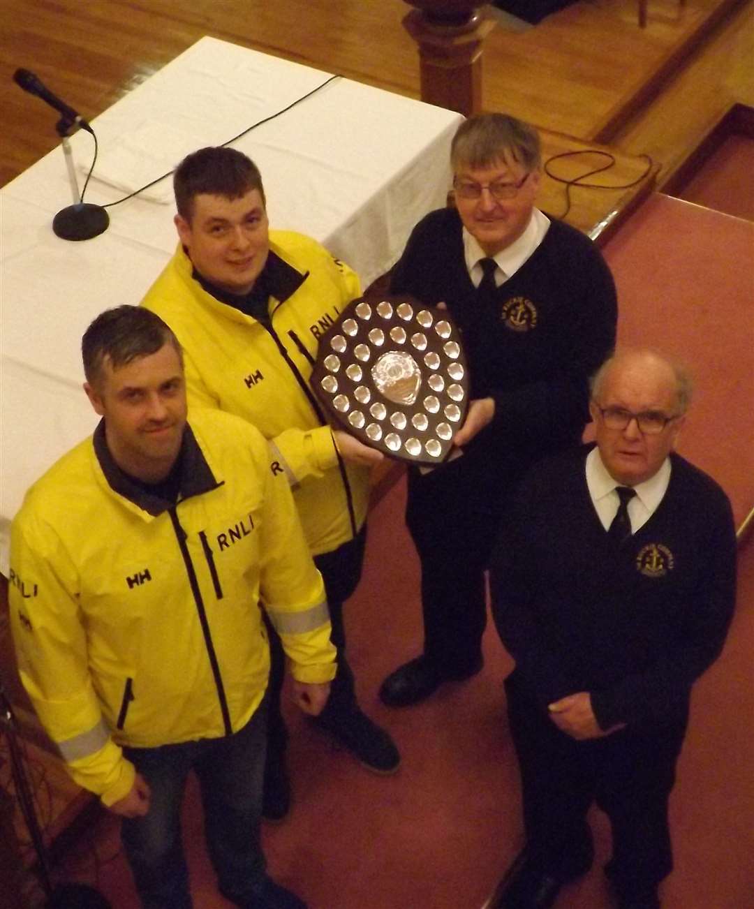 Keiran Robertson (centre left) presents the Adam Robertson Memorial Shield to Company Captain Alan McIntosh BEM (centre right). Also pictured are RNLI Buckie deputy mechanic Brian Forbes (left) and Boys' Brigade Lieutenant Gordon Pirie MBE (right). Picture: Buckie RNLI