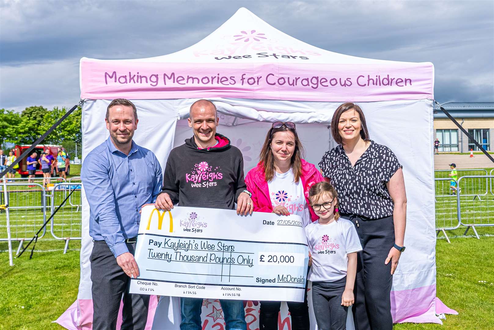 Craig MacLean and Mel Harrison from McDonald’s handing over the cheque to Jonathan and Anna Cordiner and their daughter Emma. Photo: Stuart Ross Media.