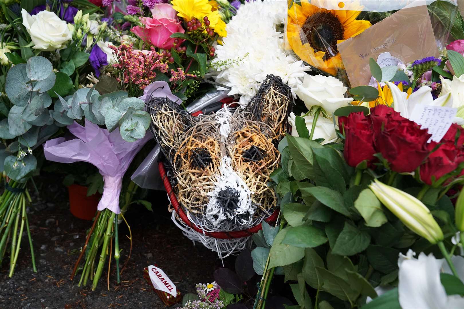 Floral tributes surround a wicker model corgi left at the gates of Balmoral Castle in Aberdeenshire (Owen Humphreys/PA)