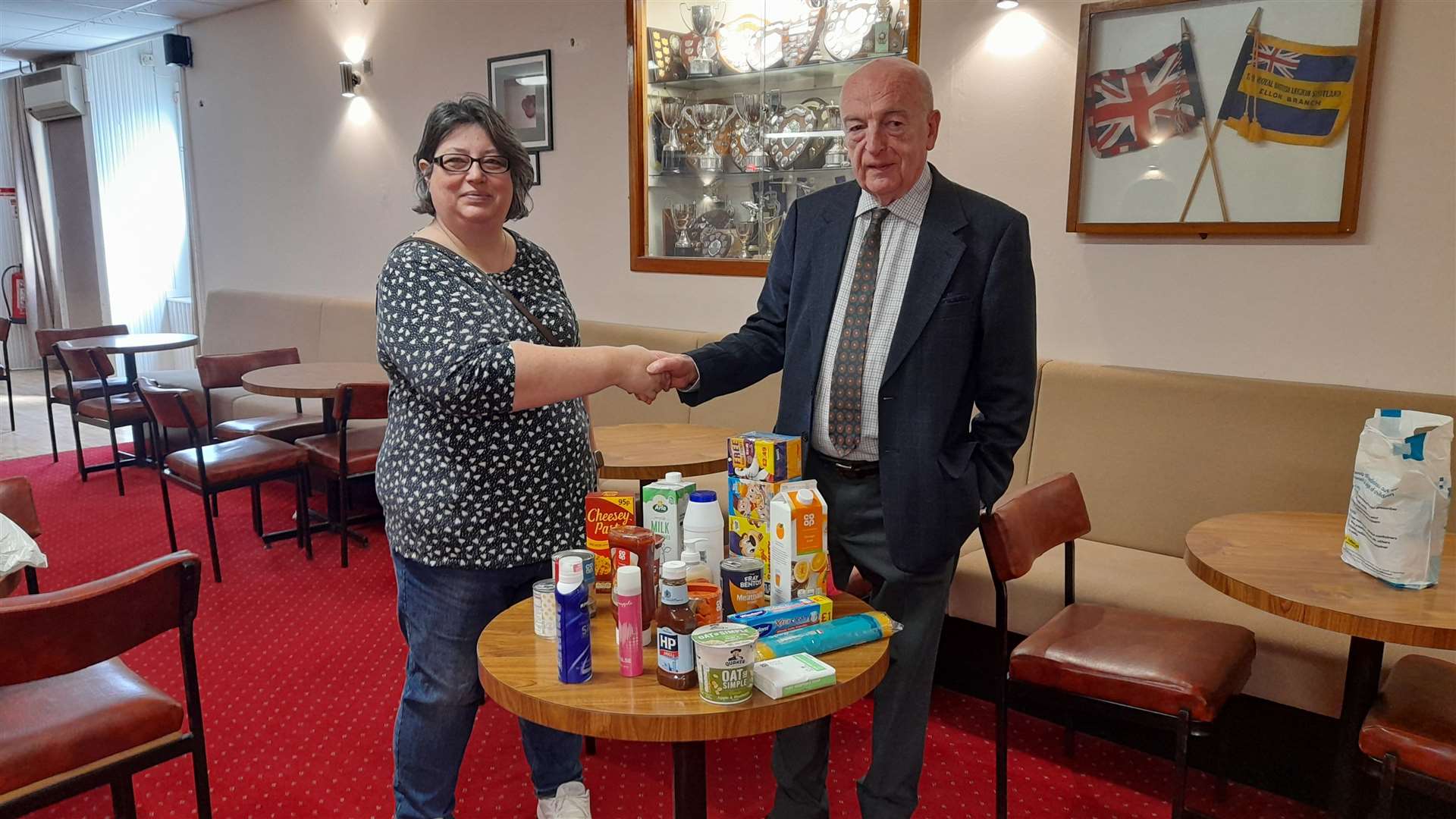 Ellon Foodbank's Karen Butchart collects the donation from Ellon Legion's Douglas Watson.