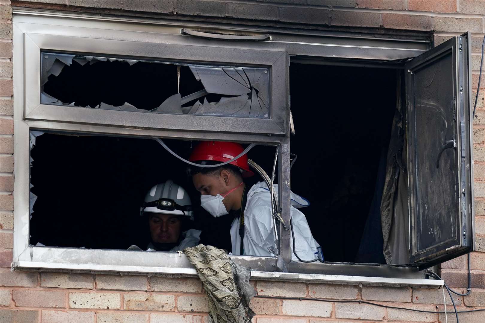 Fire investigators examine an upstairs room at the house (Jacob King/PA)