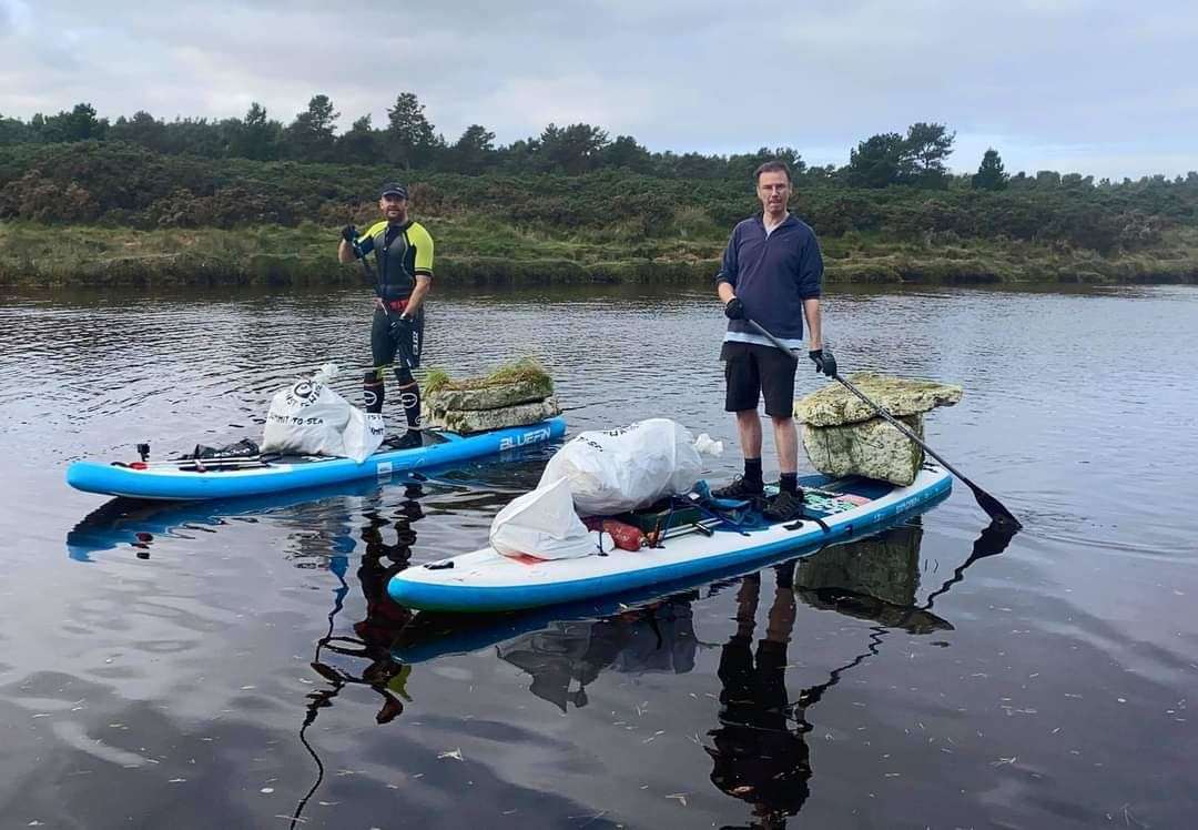 Two of the clean-up crew from Moray Stand-up Paddleboarding Club with some of the litter haul from the banks of the River Lossie.