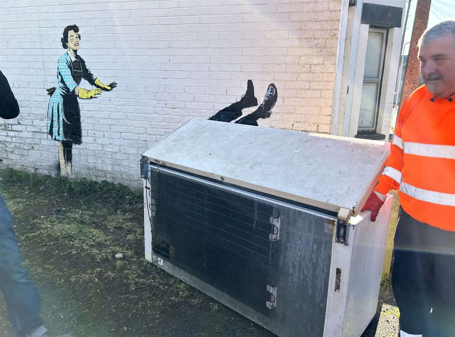 People wearing high-vis workwear in Margate removing a chest freezer which formed part of new artwork by street artist Banksy (@danbamhiggins/PA)