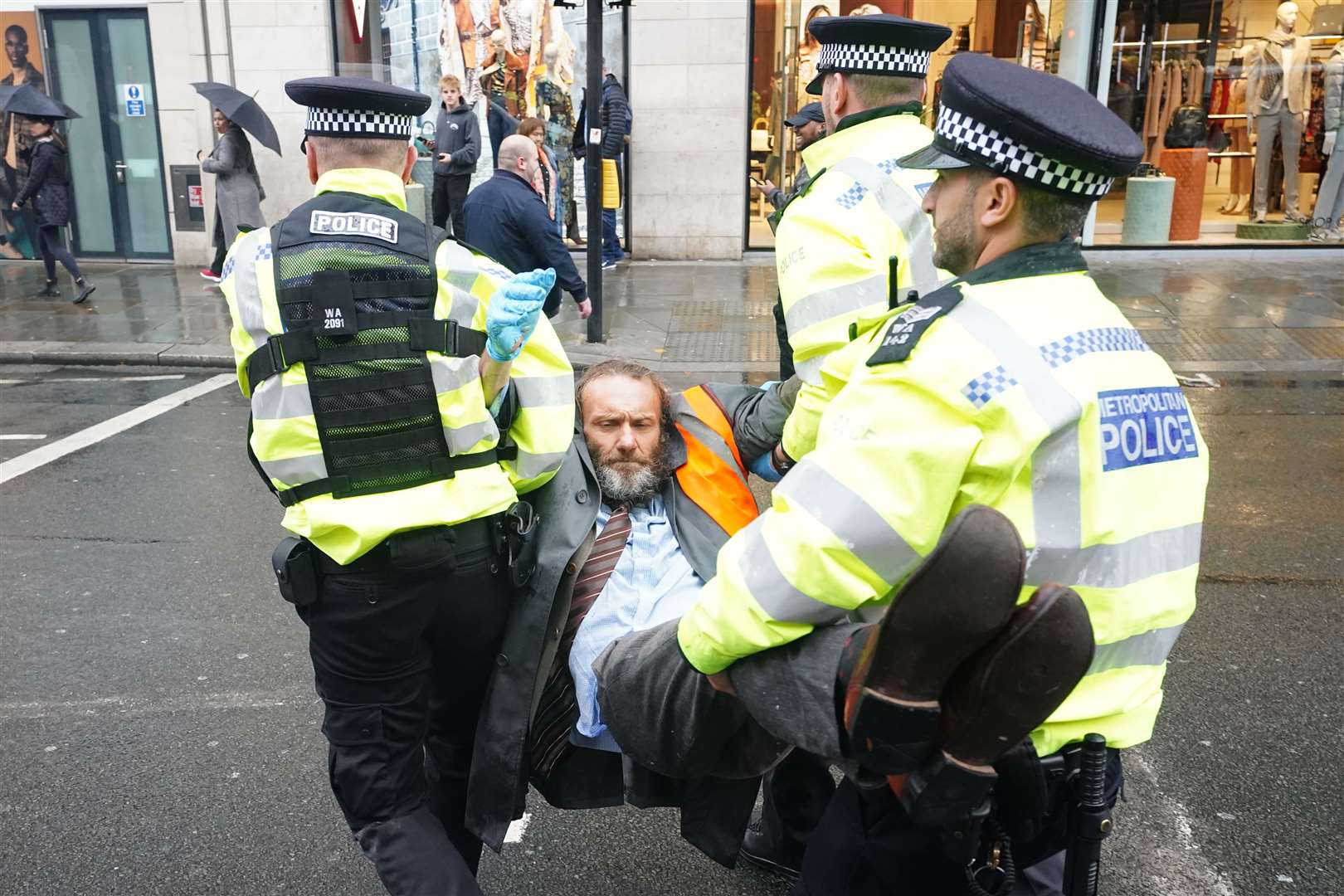 Police officers deal with activists from Just Stop Oil during their protest outside Harrods department store in Knightbridge, London in October (Ian West/PA)