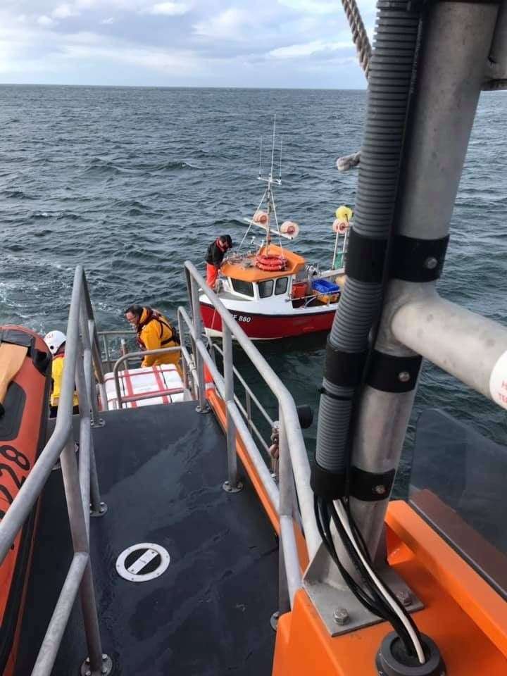 Buckie RNLI crew work to establish a tow to the stricken creel boat.