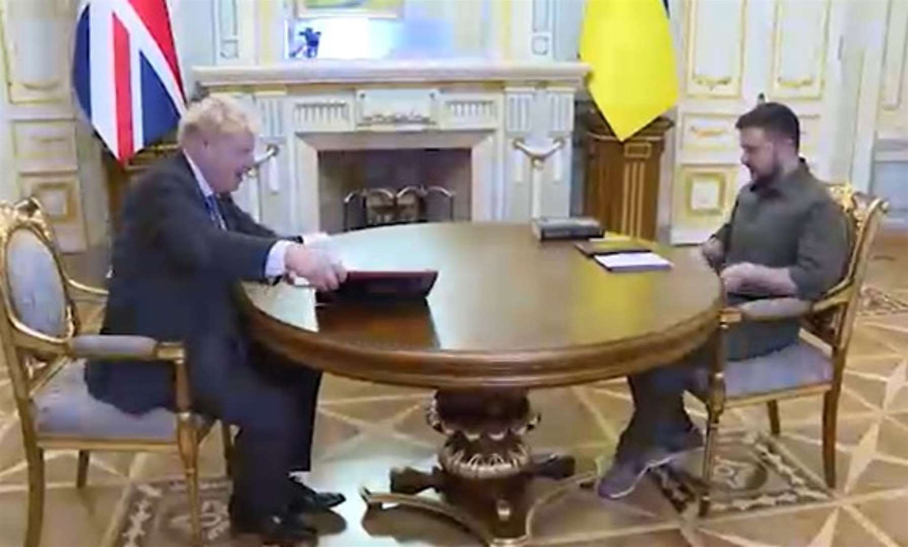 The Prime Minister and Ukrainian president sat down for talks after Mr Johnson gave his host a biography of the Queen seen next to him (Ukrainian Presidential Press Office/PA)