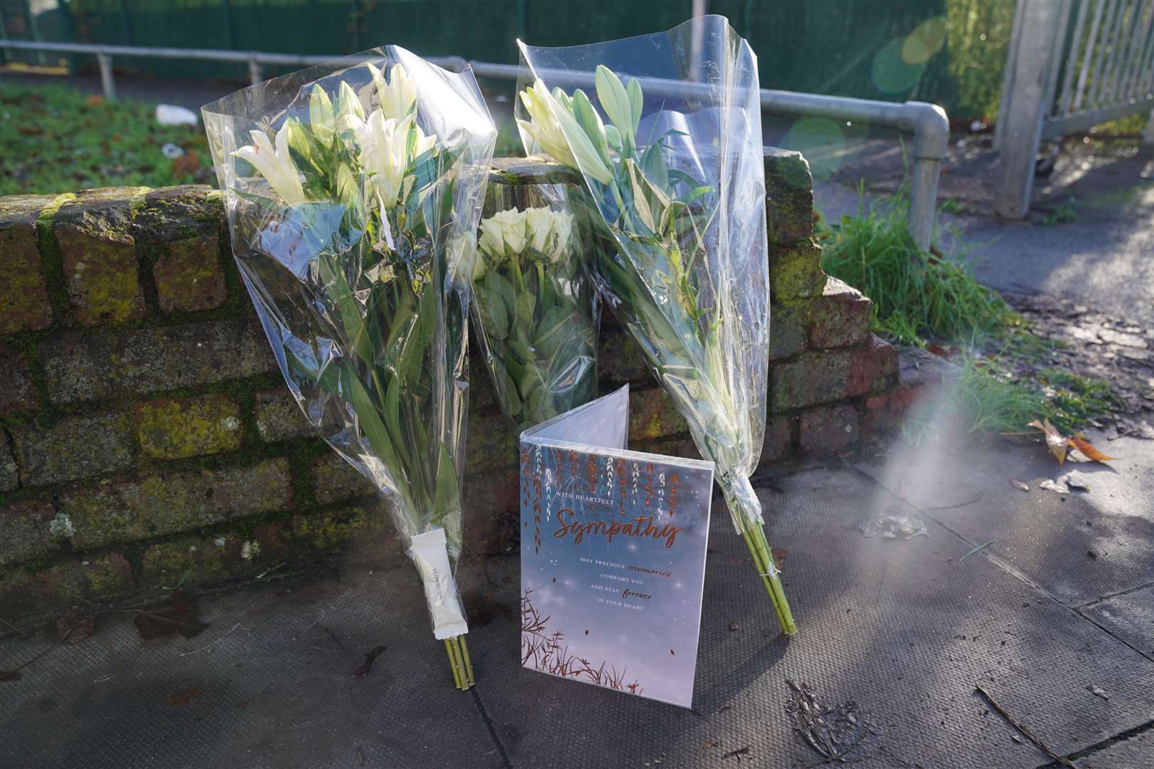 A floral tribute and card were left outside the police cordon (Lucy North/PA)