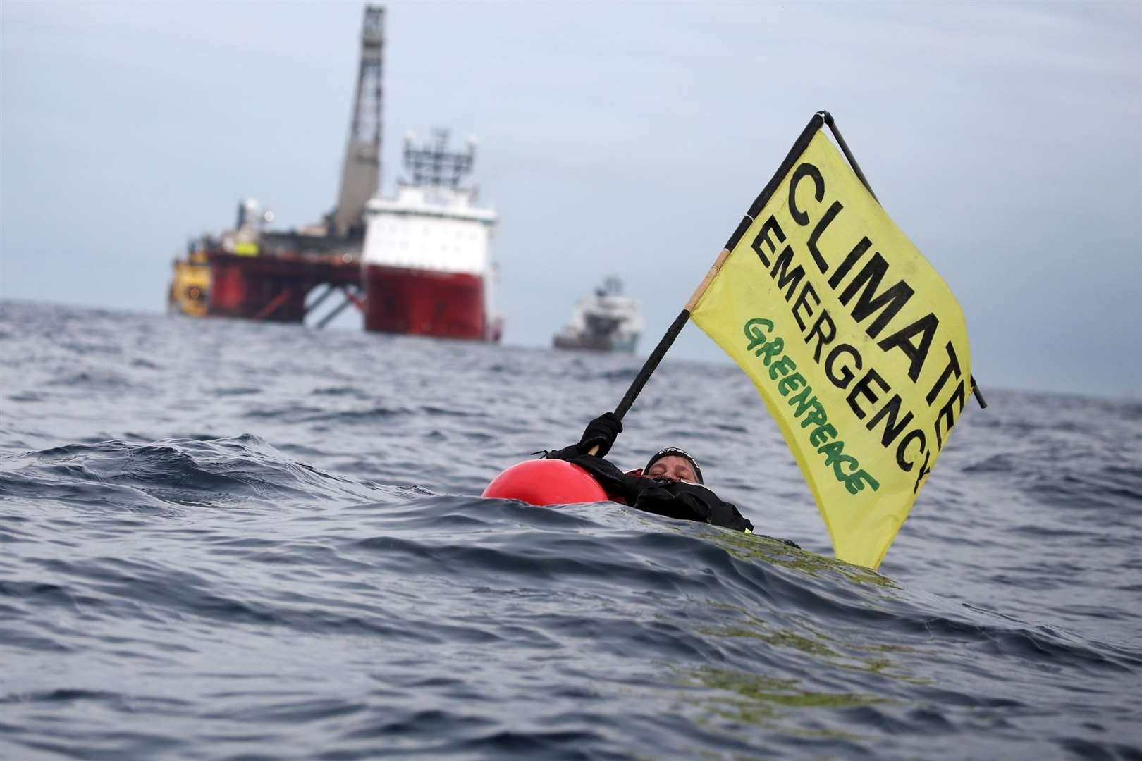 Greenpeace swimmer Sarah North holds a banner floating in front of BP rig on day 11 of the protest in the North Sea.