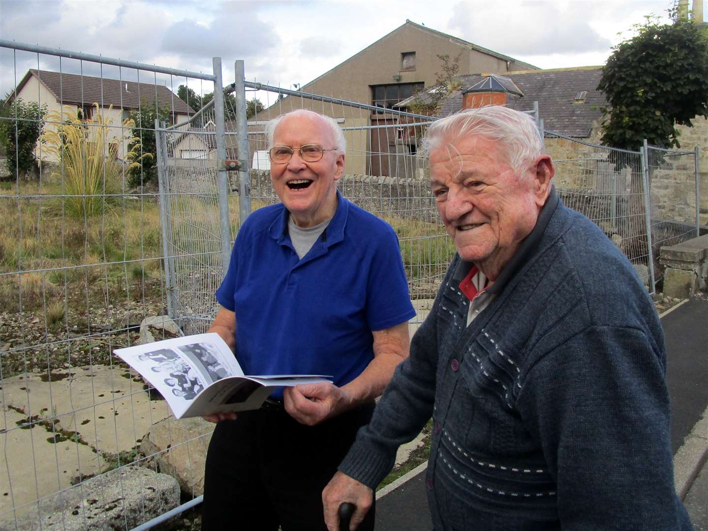 Hugh Youngson (aged 88) and Charlie Anderson (91), in front of the site of the former Marnoch Memorial Hall, get a preview of the new book. Their grandfathers were involved in building the hall as the contractors.