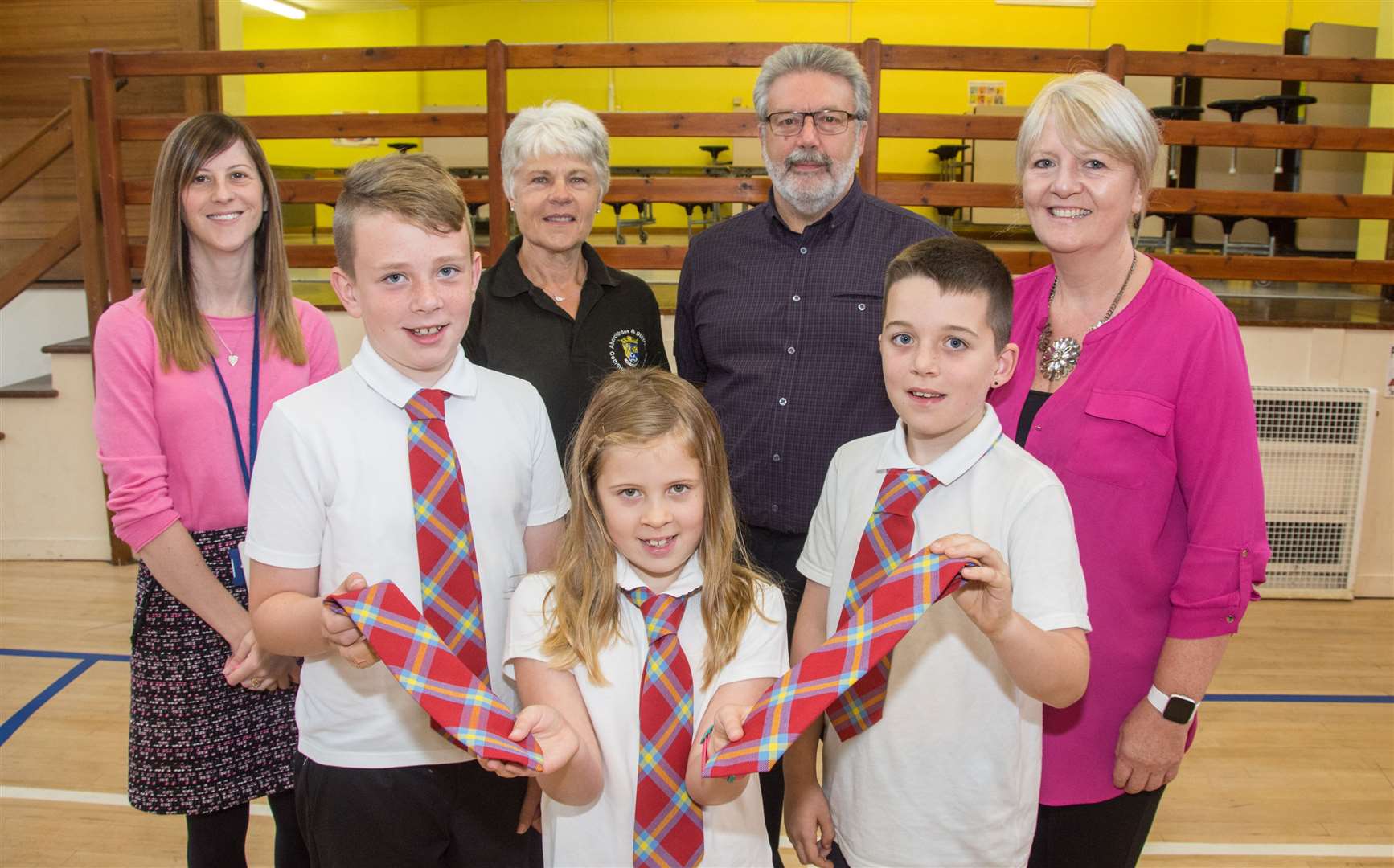 With the new tartan ties are Aberchirder Primary School Pupils Alex Barrie, Becca Brown and Alfie Dorsett. Also pictured are (back row from left): head teacher Lisa Campbell; Brenda King chairwoman of Aberchirder Community Association; Kevin Stearman of Deuchers Windfarm Community Fund and Zandra Stuart who entered the competition. Picture: Becky Saunderson. Image No.044660.