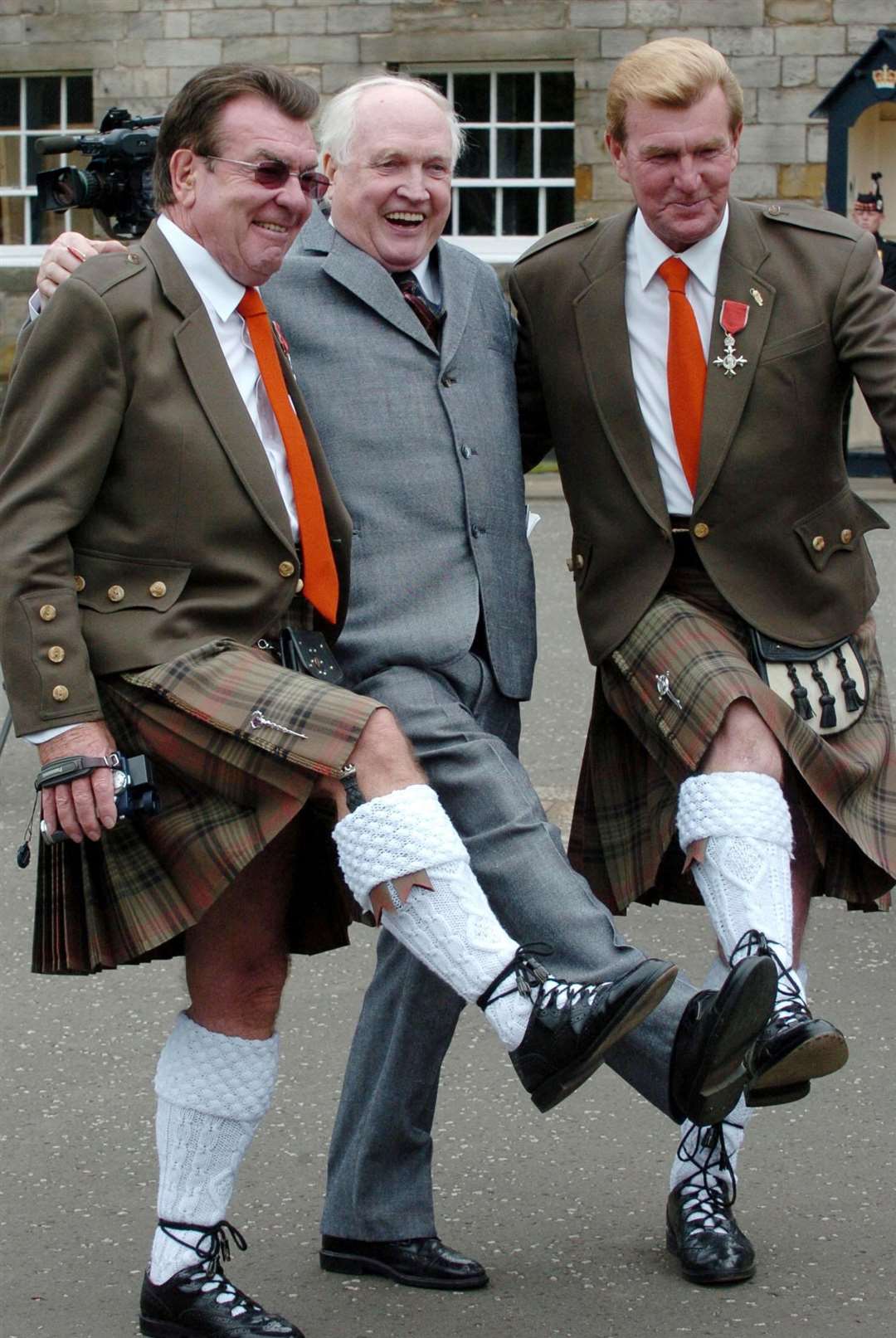 George Wyllie, centre, celebrates with Thomas and Jack Alexander after being made an MBE in 2005 (PA)