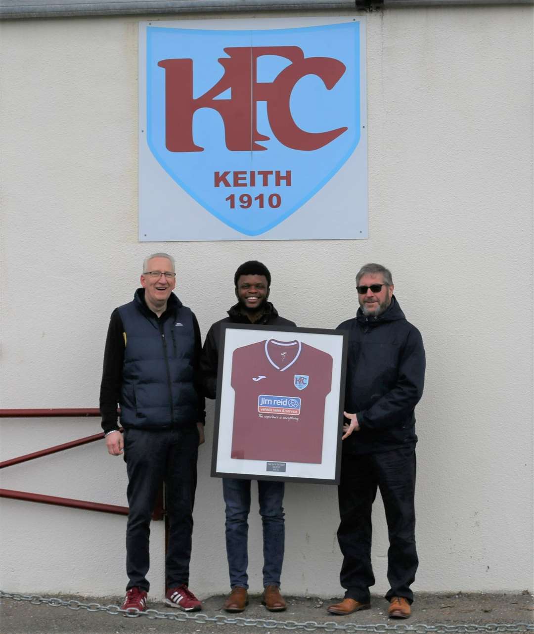 Charlie Simpson presents a framed Keith shirt to Rhema Akinola and Alan Mathewson from Koehler Renewable Energy UK Ltd