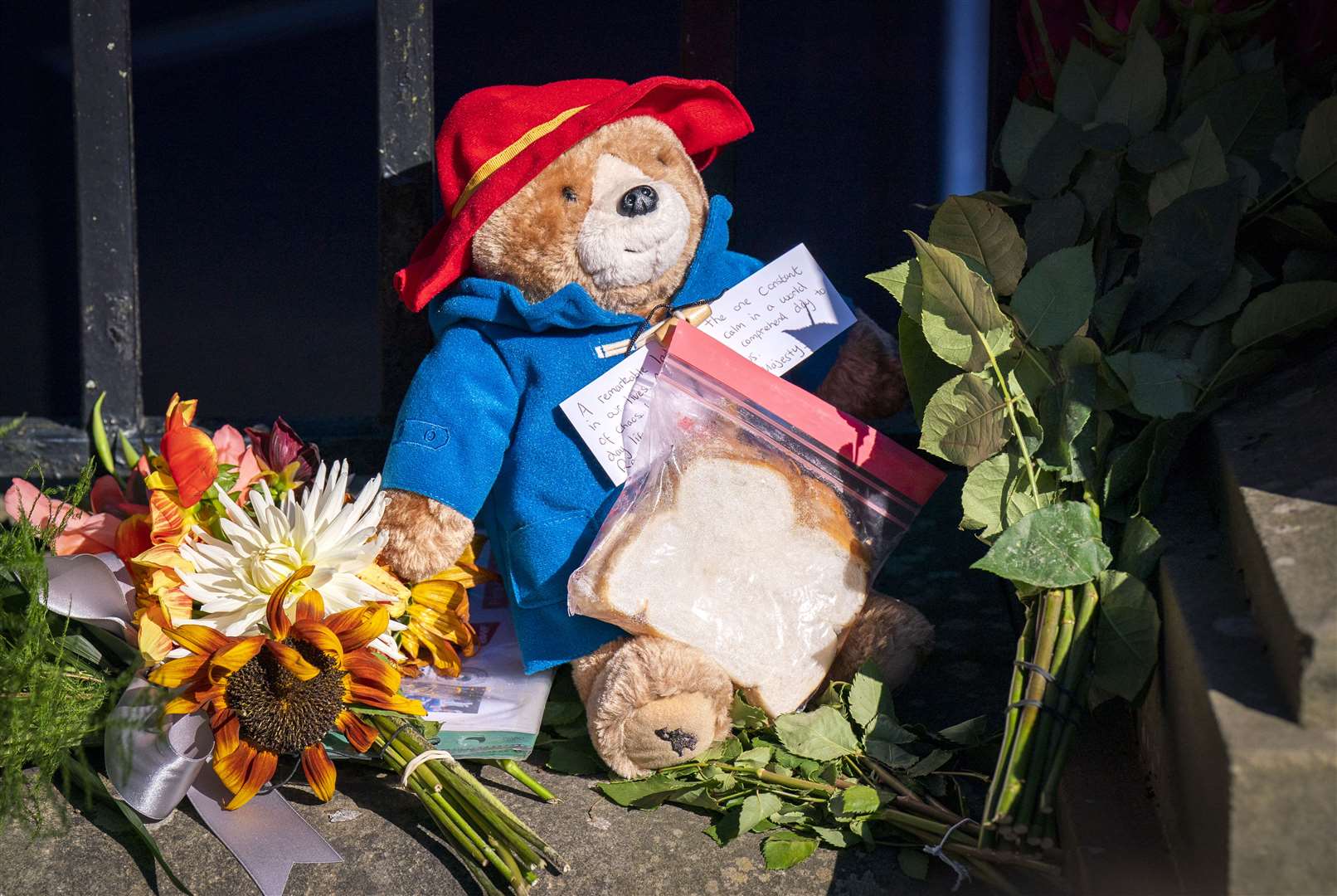 A Paddington Bear toy is left amongst flowers and tributes outside the Palace of Holyroodhouse, Edinburgh (Jane Barlow/PA)