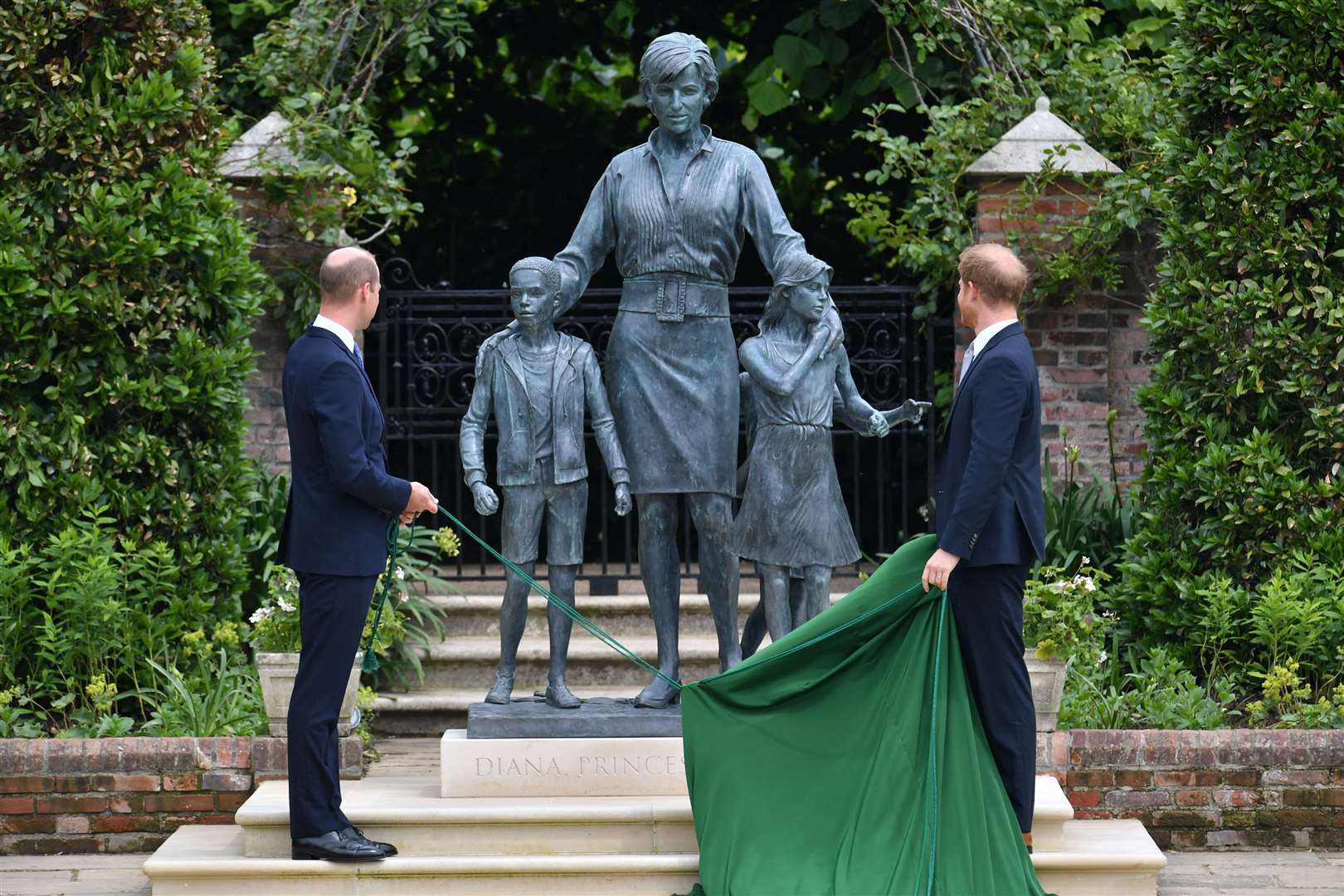 The Duke of Cambridge and Duke of Sussex look at a statue they commissioned of their mother in 2021 (Dominic Lipinski/PA)